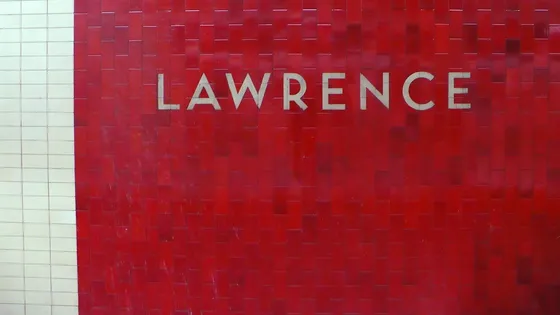Red wall tiles with the station name at Lawrence subway station.